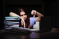 Young female student preparing for exams late at home [IBR125141746]
