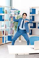 Young handsome male employee with too much work in the office [IBR125141758]