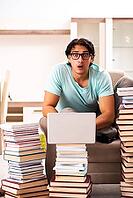 Male student with many books at home [IBR125141765]
