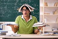 Handsome student in front of chalkboard with formulas [IBR125141769]