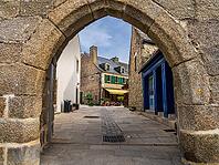 The old town and fortified Ville Close of Concarneau occupy a walled island in the Bay of Concarneau, Finistère, Brittany, France. Stone ramparts, towers, harbour buildings and surrounding water are visible in natural daylight, with the town opening towar [IBR125163369]