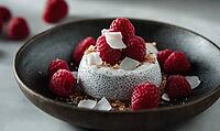 Yogurt and honey-topped chia pudding with raspberries and coconut on a rustic dark plate. AI generated [IBR125167411]