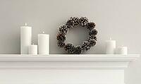 Modern white mantle with a single pinecone wreath and a few white candles. AI generated [IBR125167435]