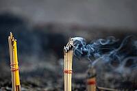 Fine smoke rises between the upright incense sticks and forms soft, swirling lines in the warm air. The bundles are carefully tied and depict a serene scene of traditional offerings such as those found in many temples and shrines, Wat Yai Chai Mongkon, Ay [IBR125177957]