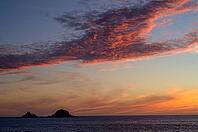 Sunset, sunset at sea, dramatic clouds, in the background rock formation The Brisons, Cot Valley Beach, Porth Nanven, coast, St Just in Penwith, Cornwall, England, Great Britain, Great Britain [IBR125177960]