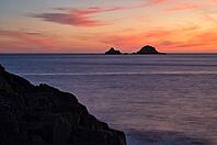Sunset, sunset at sea, dramatic clouds, in the background rock formation The Brisons, Cot Valley Beach, Porth Nanven, coast, St Just in Penwith, Cornwall, England, Great Britain, Great Britain [IBR125177973]