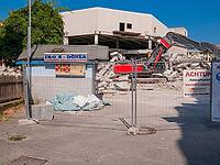 Demolition excavator next to a abandoned doner kebab snack [IBR125180343]