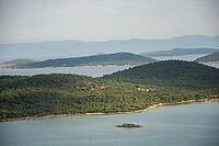 A tranquil panorama of Ayvalık's emerald islands and calm waters unfolds beneath soft, drifting clouds [IBR125180366]