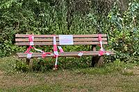 Wooden bench in nature with barrier tape and warning sign on oak procession spinner, Guxhagen, Hesse, Germany [IBR125180388]