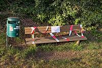Blocked park bench with warning about oak procession spinners in evening sun, Guxhagen, Hesse, Germany [IBR125180391]