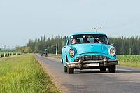 Blauer amerikanischer Oldtimer fährt auf der Landstrasse im Landesinneren von Kuba Blue American classic car traveling on the road in the countryside of Cuba [IBR125188218]