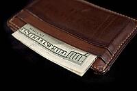 Wallet with hundred dollars bill on black background [IBR125188242]