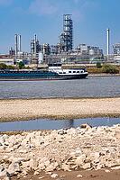 Rhine near Emmerich, extreme low water, Rhine level at 5 cm, downward trend, cargo ships sometimes have to travel with only 30 percent of the usual load, backdrop of the KLK Emmerich chemical plant, for oleochemical products, North Rhine-Westphalia, Germa [IBR113322457]