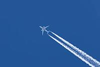 Jet passenger aircraft of TUI airlines flying in a blue sky with contrails or vapour trails behind in the atmosphere, England, United Kingdom [IBR125204134]