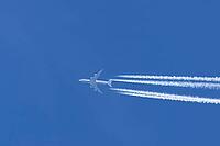 Boeing 747 jumbo jet passenger aircraft of Lufthansa airlines flying in a blue sky with contrails or vapour trails behind in the atmosphere, England, United Kingdom [IBR125204157]