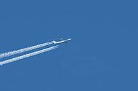 Lockheed C5 Galaxy military transport jet aircraft of the United States Air Force USAF flying in a blue sky with contrails or vapour trails in the atmosphere, England, United Kingdom [IBR125204166]