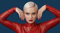 Woman with short platinum blond hair wearing a red leather outfit against a blue background. Red fingernail polish, AI generated [IBR125237526]