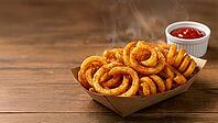 A cardboard boat filled with spicy curly fries with a ramekin on the side filled with ketchup. An appetizer and fast food favorite, AI generated [IBR125237528]