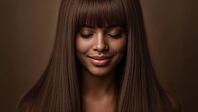A beautiful African American model with a knowing smile and long brown hair looking downwards. Flawless complexion, brown background. Sensual portrait, AI generated [IBR125237541]