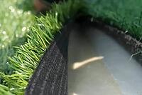 Spreading artificial turf in the stadium, rolling out rolls of lawn and leveling [IBR125242444]