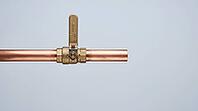 Ordinary copper pipe with a closed shutoff valve, calm exterior hiding the violent pressure transient of water hammer, studio shot, AI generated [IBR125242470]