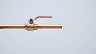 Ordinary copper pipe with a closed shutoff valve, calm exterior hiding the violent pressure transient of water hammer, studio shot, AI generated [IBR125242479]