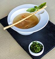Tasty soup with greens on the black plate [IBR125261548]