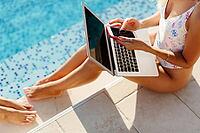 Woman using laptop and smartphone on beach pool. Woman freelancer working on laptop on edge of pool. Female study online easily. Using multiple devices [IBR125261627]