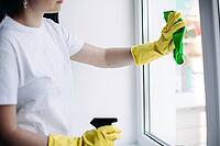 Crop of incognito brunette housewife cleaning dirty window. Housemaid wearing white t shirt and yellow protective gloves wiping glass with rag. Concept of housework and apartment service [IBR125261634]