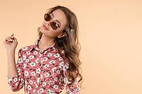 Front view of stylish girl wearing white light dress looking at camera and posing on isolated background. Pretty young woman with makeup and hairstyle enjoying new outfit. Concept of fashion [IBR125280310]
