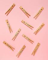Wooden clothes pins on a pink background [IBR125280322]