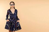 Full length studio portrait of beautiful slim brunette young woman in white sunglasses and colored dress and beige high heels posing with skirt stretching in hands. Flirting with camera. Isolate. Blank space for text [IBR125280339]