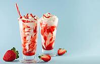 Strawberry milkshake with whipped cream and berry syrup in the tall glass on blue background [IBR125280362]