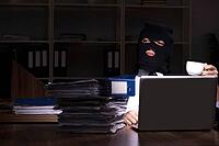The male employee steals information in the office at night [IBR125304688]