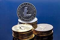 A single litecoin coin on top of a pile of crypto currency [IBR125324138]
