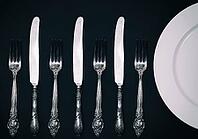 Half empty white plates, vintage knife and fork on black table, view from above [IBR125331115]