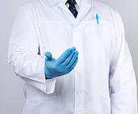 Doctor in a white coat with buttons and blue latex gloves holds out his hand forward, concept of invitation, handshake, white background [IBR125331117]