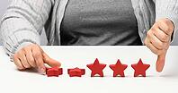 Customer experience feedback concept. Red stars, poor rating about services with a female hand. White table [IBR125331126]