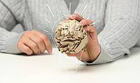 Female hand holds a crumpled brown ball of paper. New idea, brainstorming [IBR125331137]