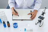 Scientists researching in laboratory in white lab coat, gloves analysing, looking at test tubes sample, biotechnology concept [IBR125331166]
