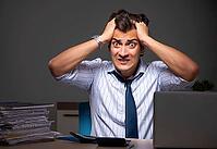 The young finance manager works late at night in the office [IBR125331168]