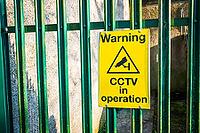 Close up photo of warning sign board on green fence [IBR125331169]