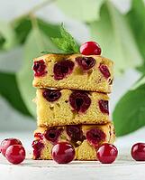 Baked pieces of sponge cake with red ripe cherries on a white wooden board [IBR125331185]