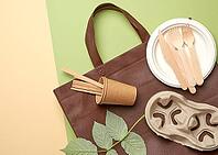 Disposable paper utensils from brown craft paper and recycled materials on a green background, plastic rejection concept, zero waste [IBR125331192]