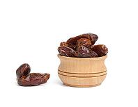 Heap of dried dates in a wooden bowl and isolated on a white background, close up [IBR125344247]