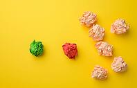 Crumpled sheets of colored paper on a yellow background. Solution concept, brainstorming, opposition and confrontation, mediator in resolving the issue [IBR125344254]