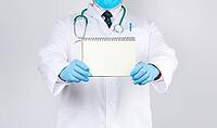 Male doctor in a white coat and medical blue gloves holds a notebook with blank white sheets on a white background, place for an inscription [IBR125344268]