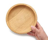 Hand holds an empty brown wooden plate on a white isolated background, top view [IBR125344283]