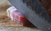 Woman's Hand Slicing Bacon with Knife [IBR125344290]
