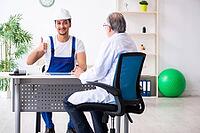 Young male contractor visits old doctor [IBR125344321]